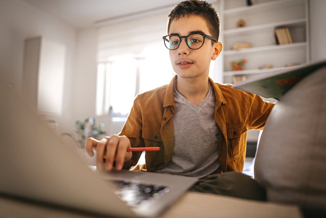 Schüler mit Brille am Laptop